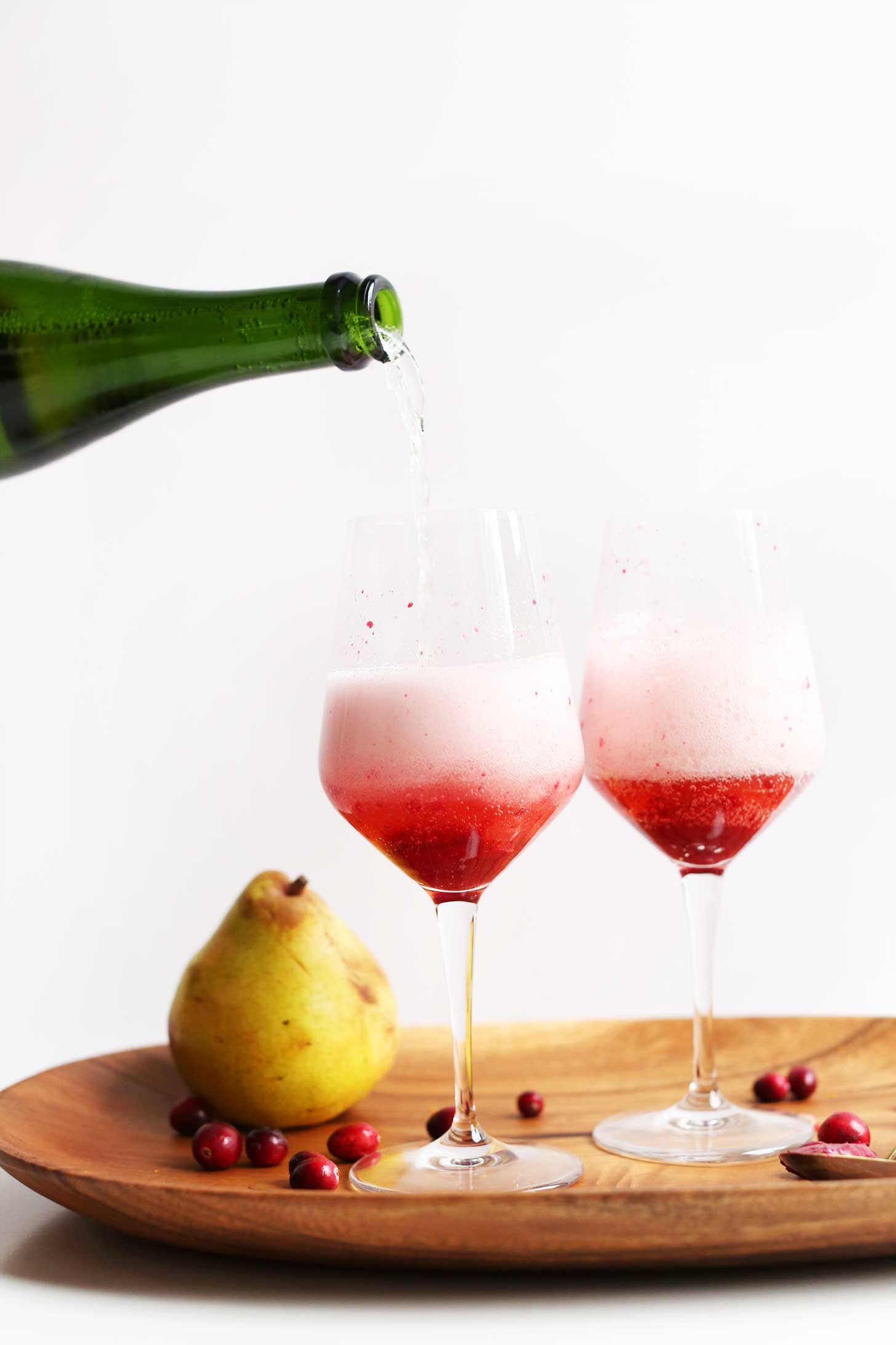 Pouring champagne for our 5-Ingredient Champagne Mimosas with Cranberry-Pear Reduction