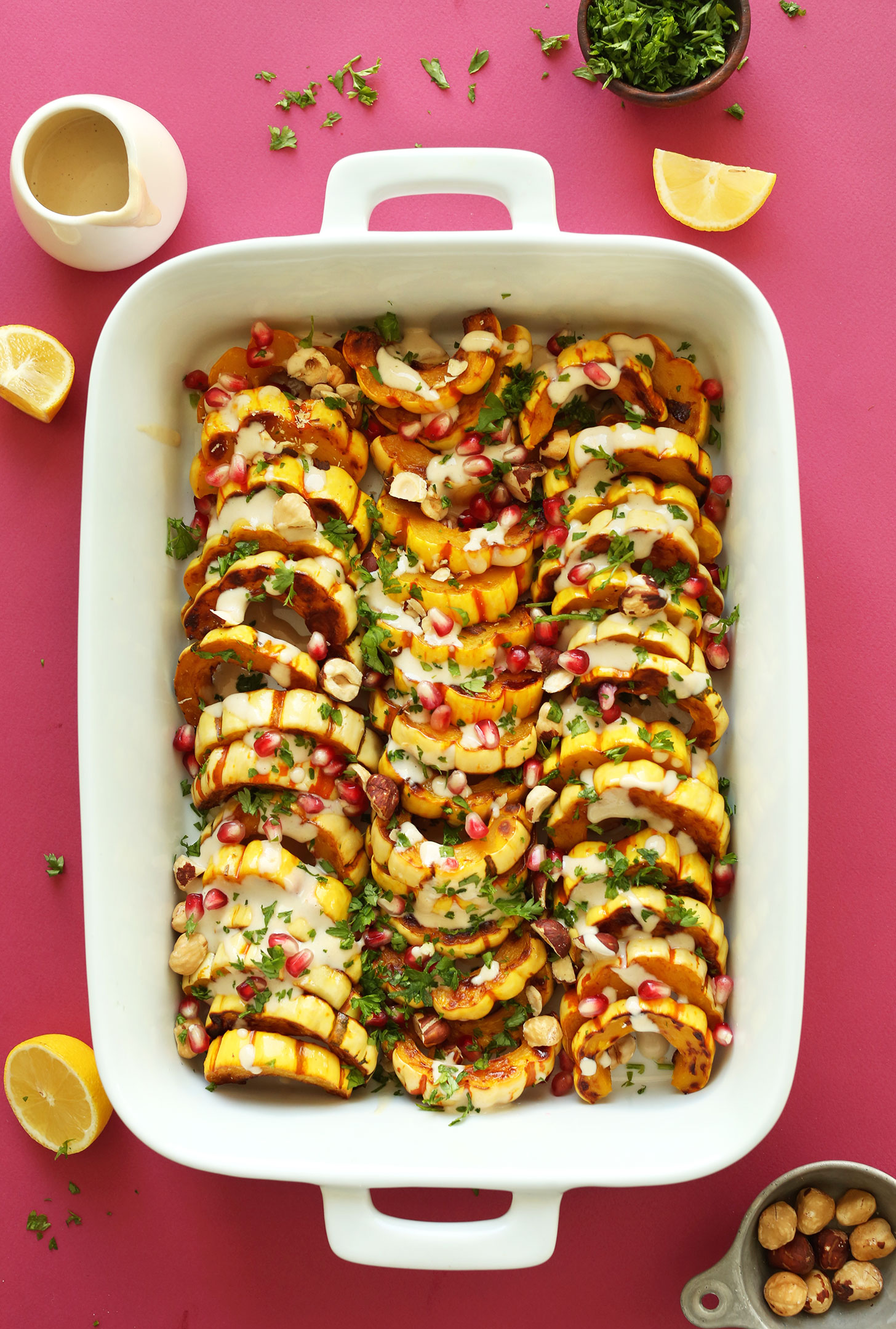 Baking pan filled with our recipe for Delicata Squash Bake with Hazelnuts, Pomegranates, and Tahini Sauce