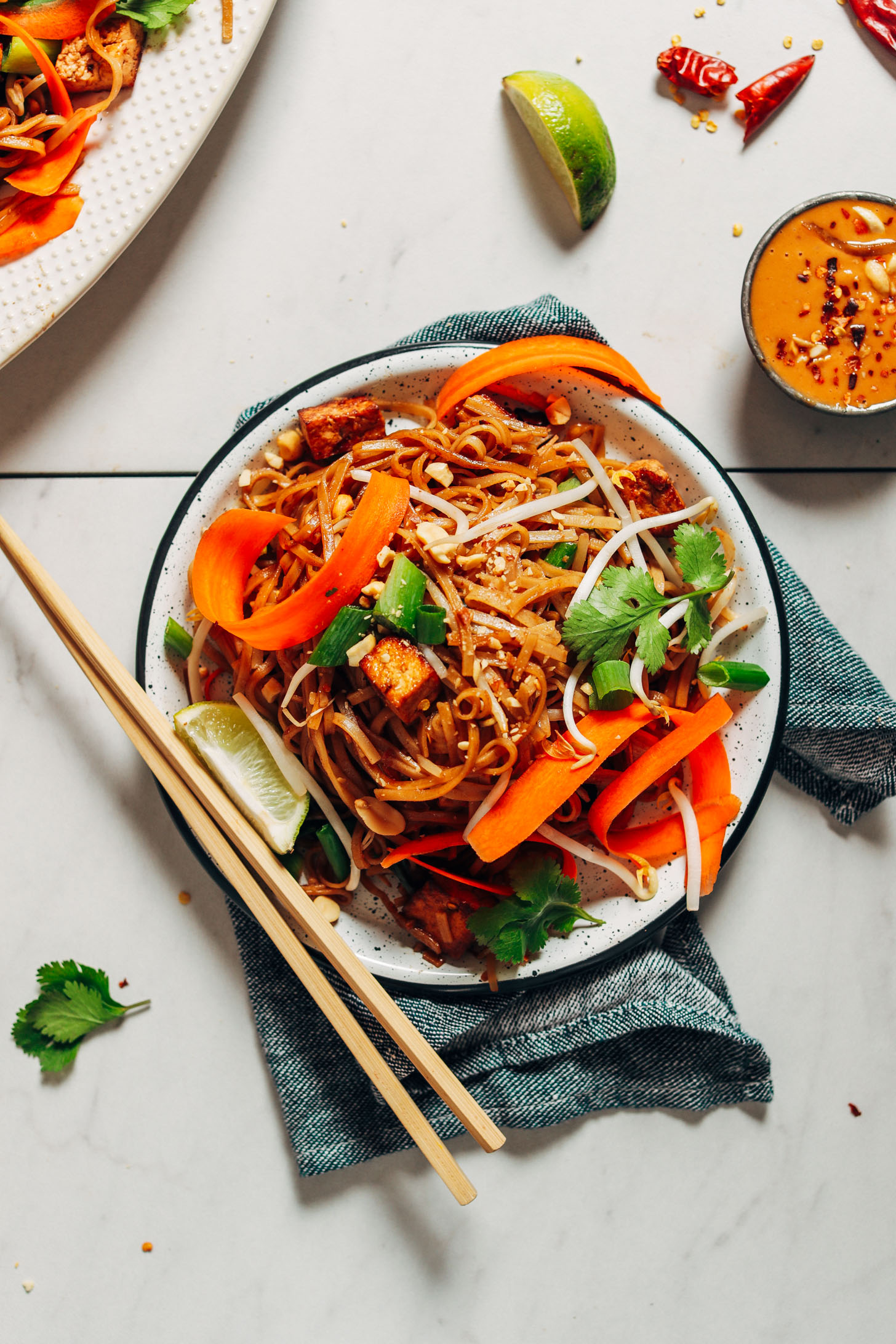 Plate of Easy Pad Thai with Tofu topped with carrot ribbons, bean sprouts, and cilantro