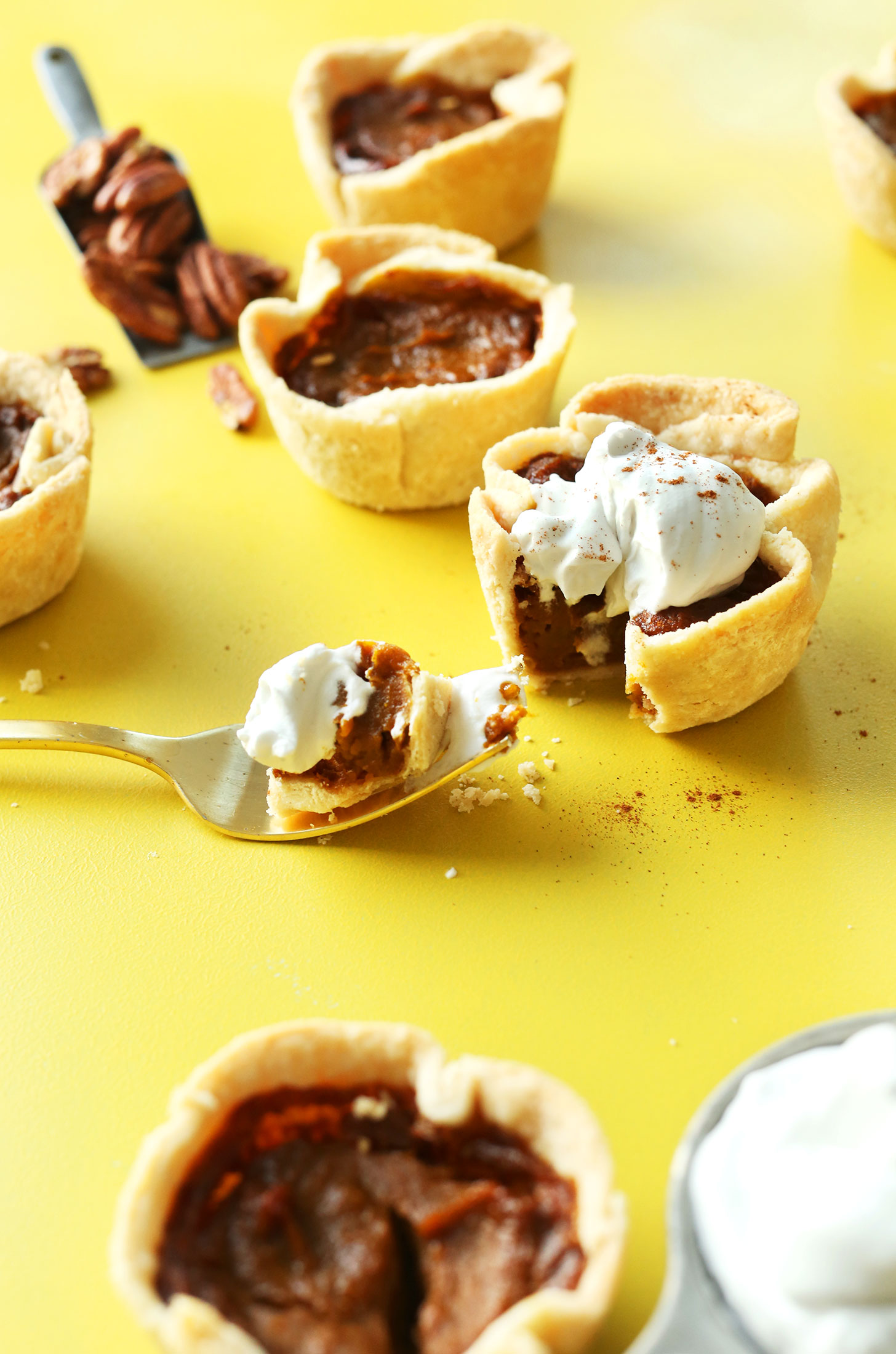 Bite of Pumpkin Pie sitting beside several mini pies