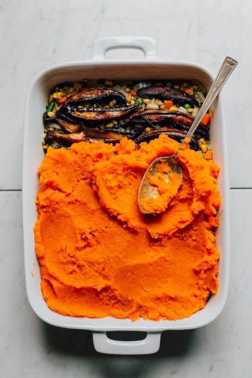 Spreading the sweet potato layer on this AMAZING Sweet Potato Lentil Shepherd's Pie for this plant-based Thanksgiving dish