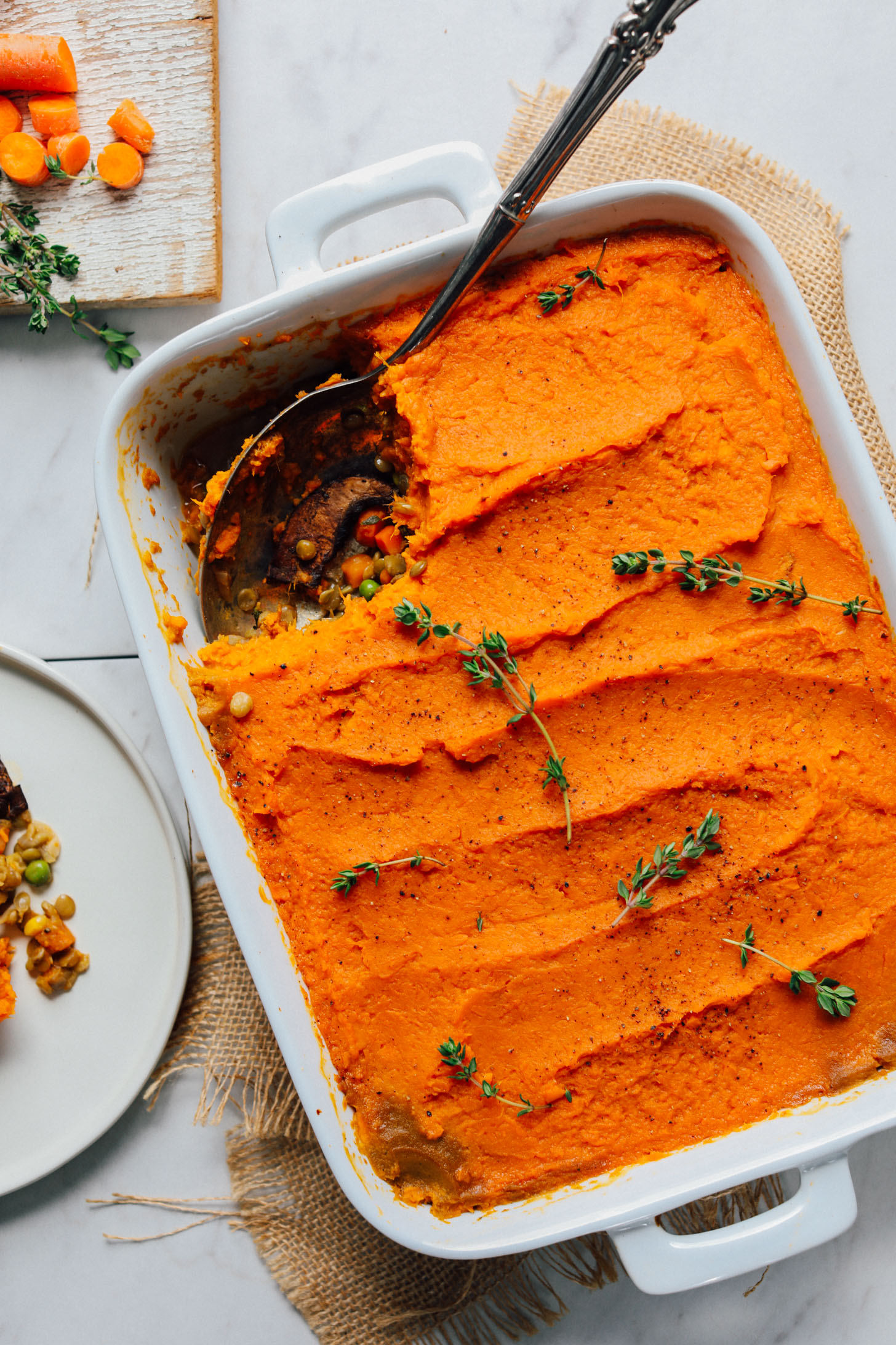 White ceramic baking dish filled with Lentil Shepherd's Pie with a Sweet Potato Crust