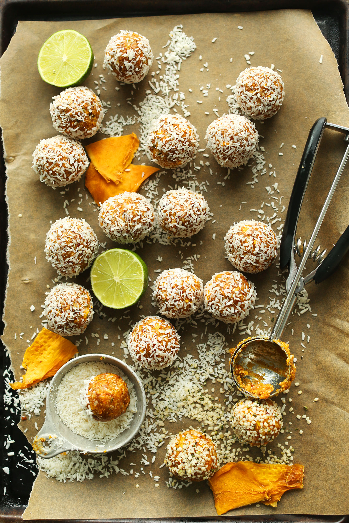 Parchment-lined baking sheet with gluten-free vegan Dried Mango Energy Bites