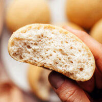 Hand holding a gluten-free dinner roll to show the inner texture