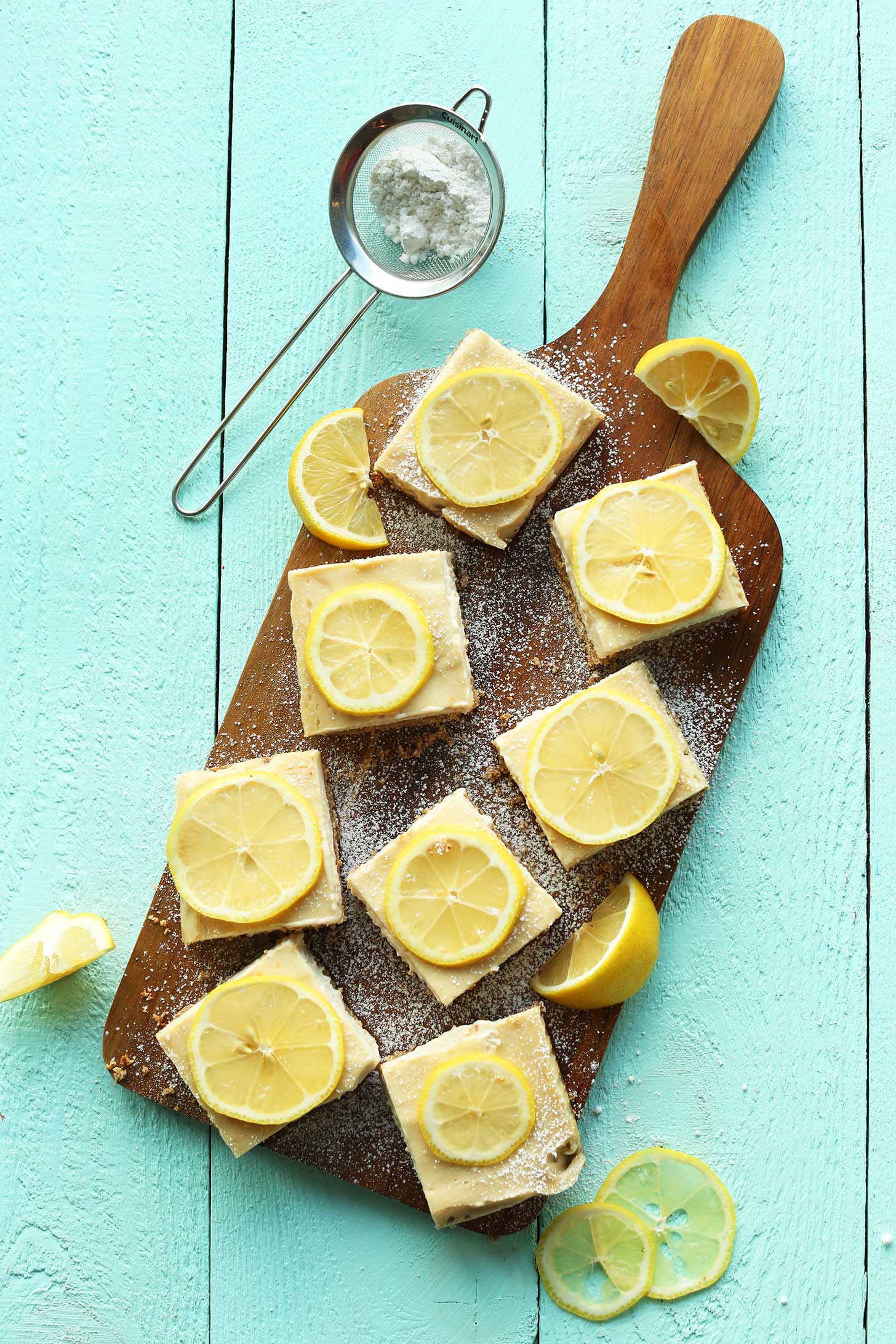 Wood platter with squares of our gluten-free vegan lemon bars recipe