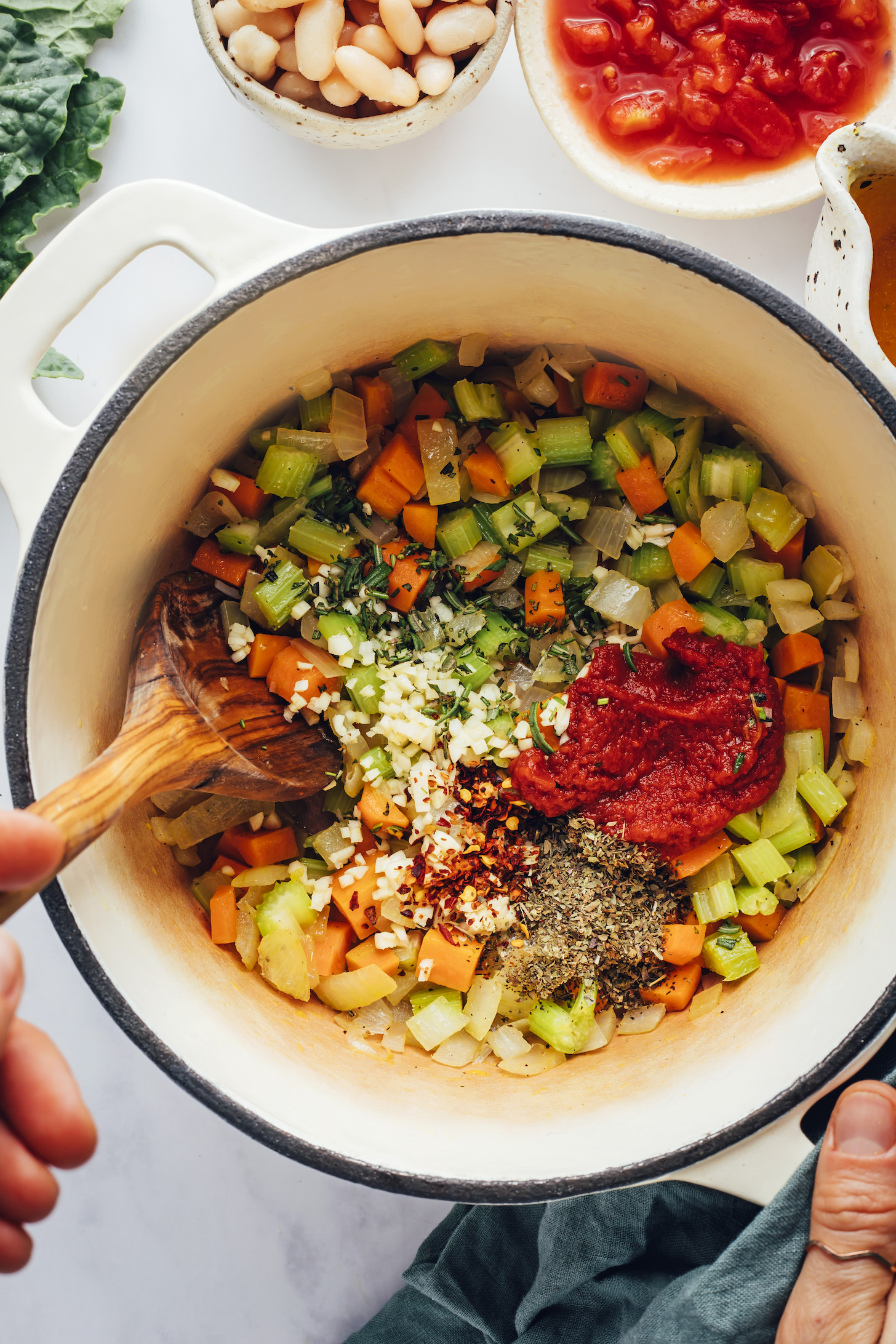 Tomato paste, garlic, red pepper flakes, and herbs over a pot of sautéed onion, celery, and carrots