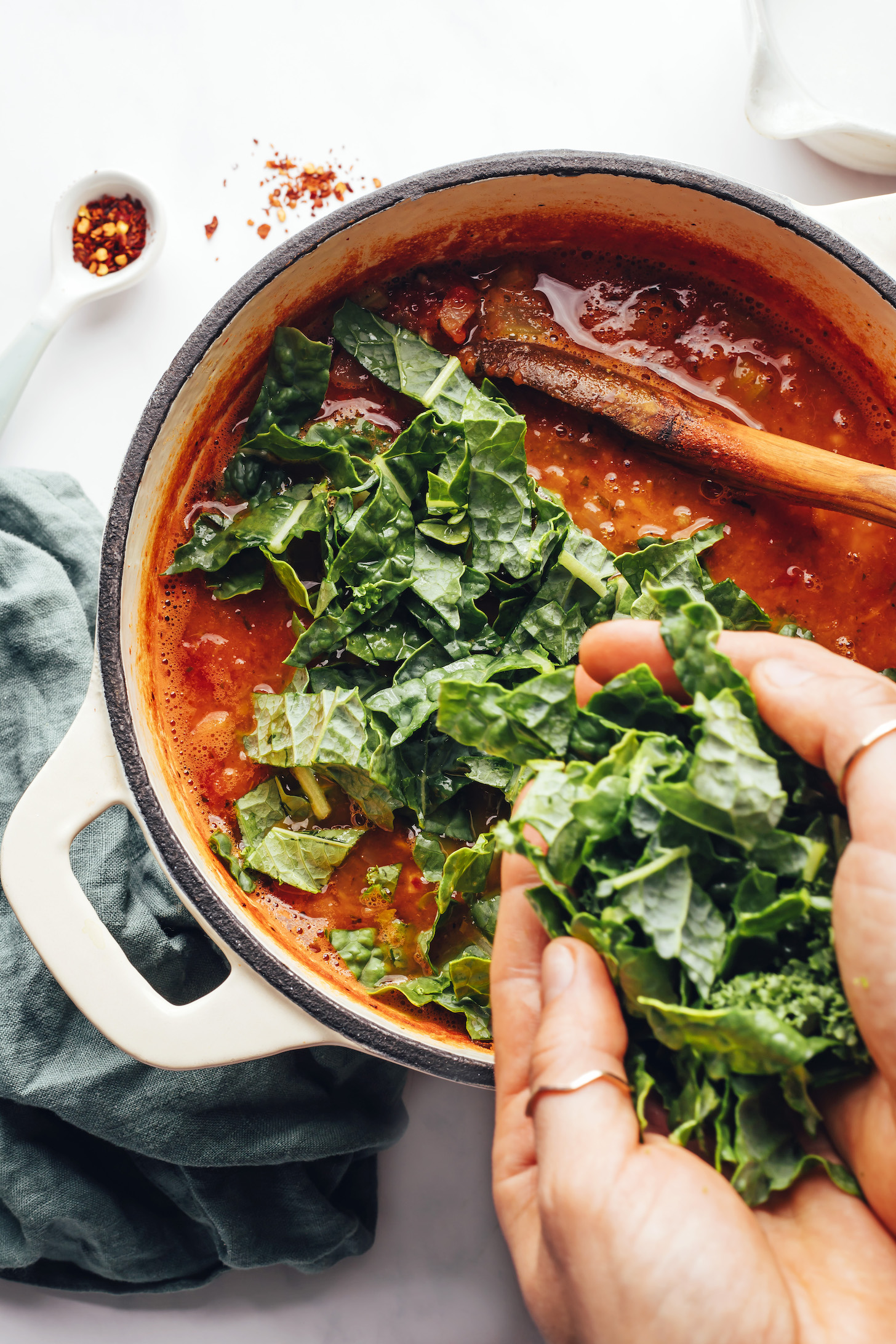 Adding chopped kale into a soup pot