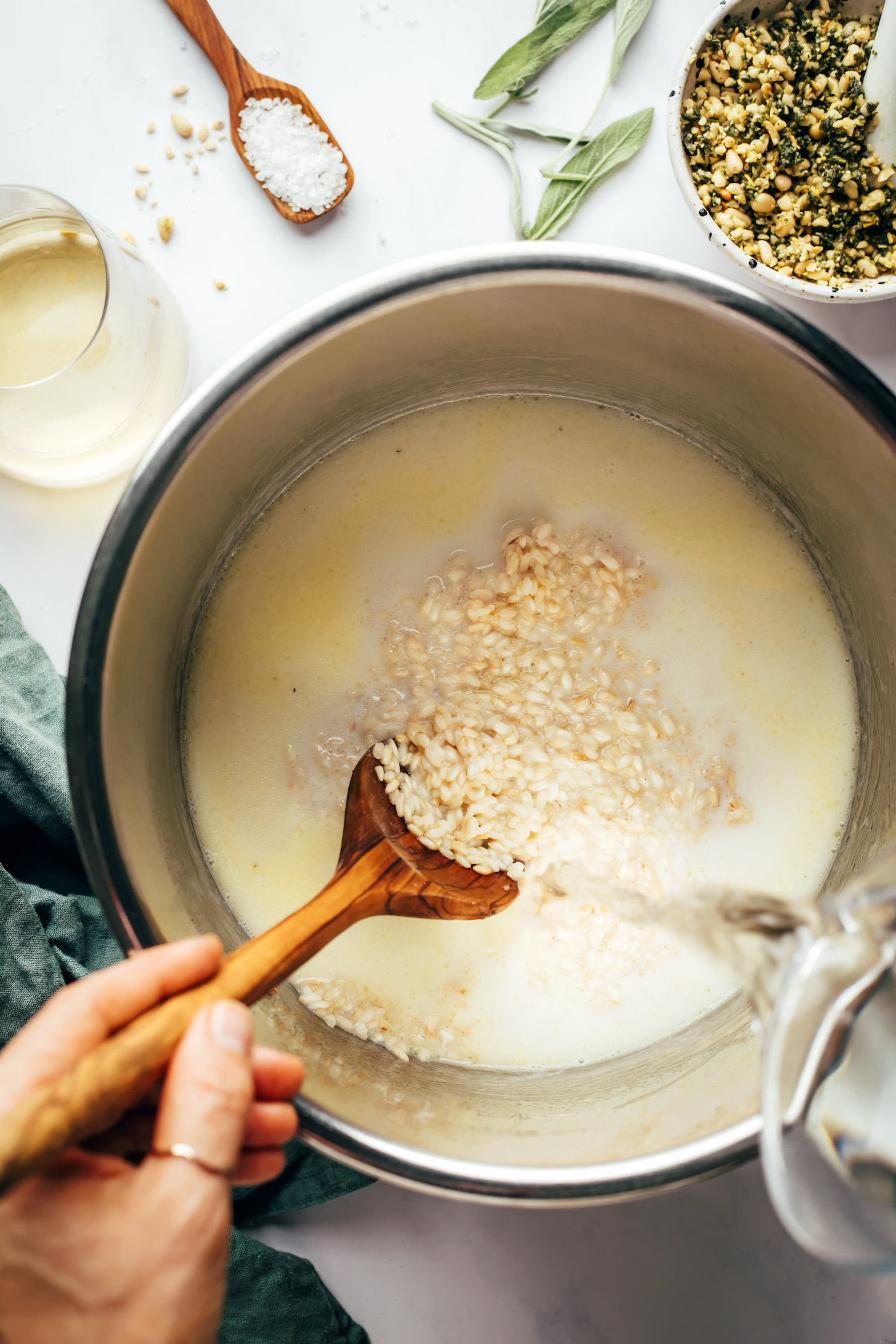 Adding water over a creamy arborio rice mixture in the Instant Pot