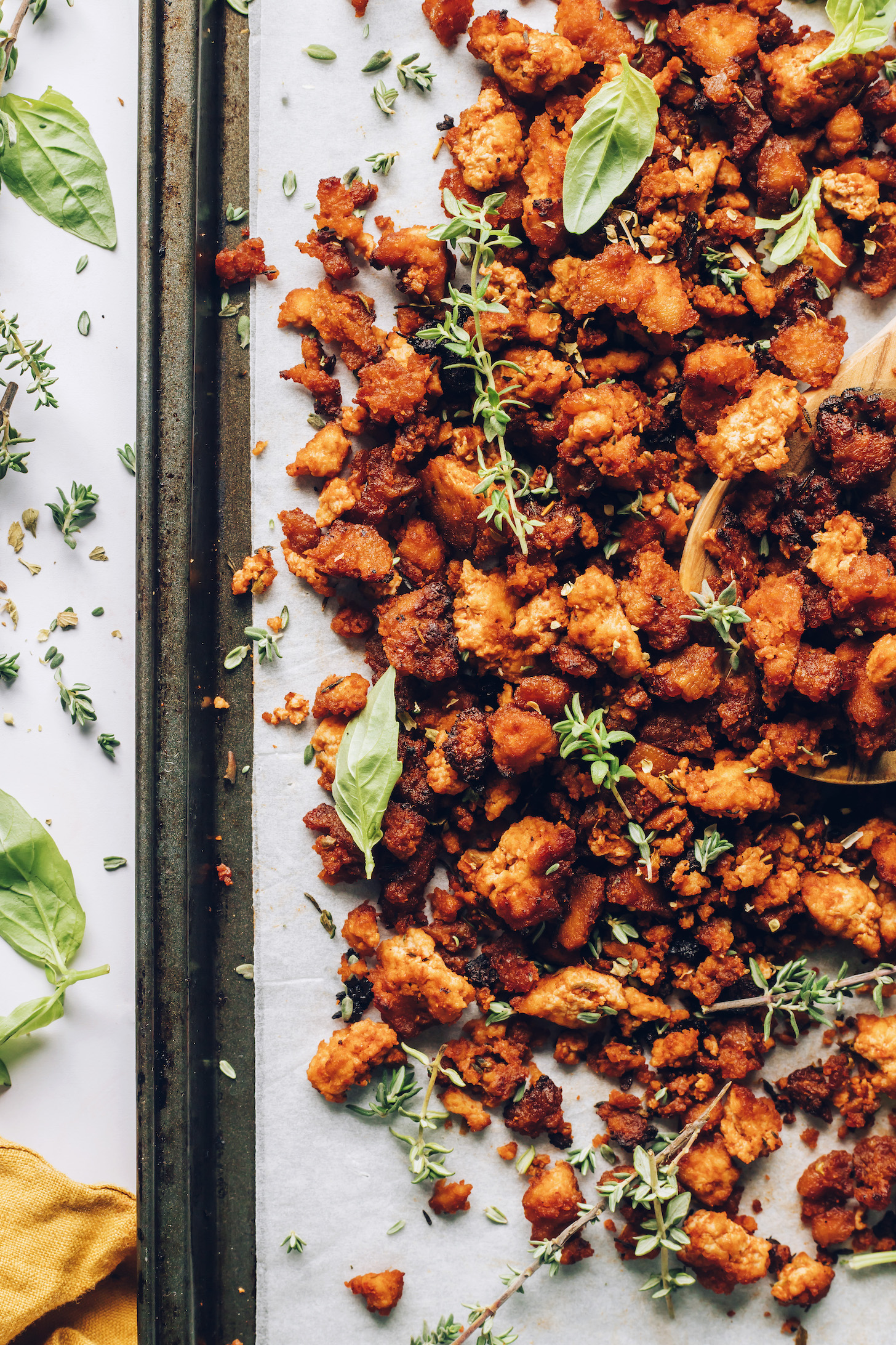 Baking sheet of Italian herb crispy baked tofu topped with fresh thyme and basil