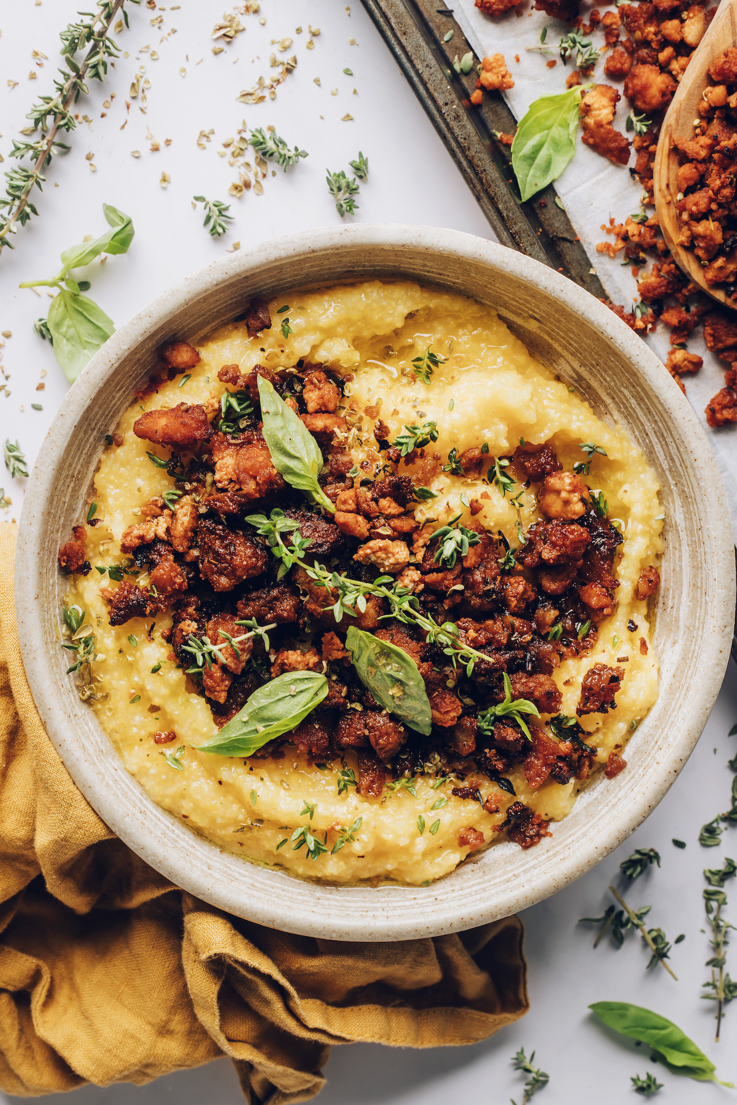 Bowl of polenta topped with crispy baked tofu and Italian herbs