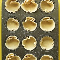 Mini muffin tin filled with Coconut Oil Pie Crust ready to be baked