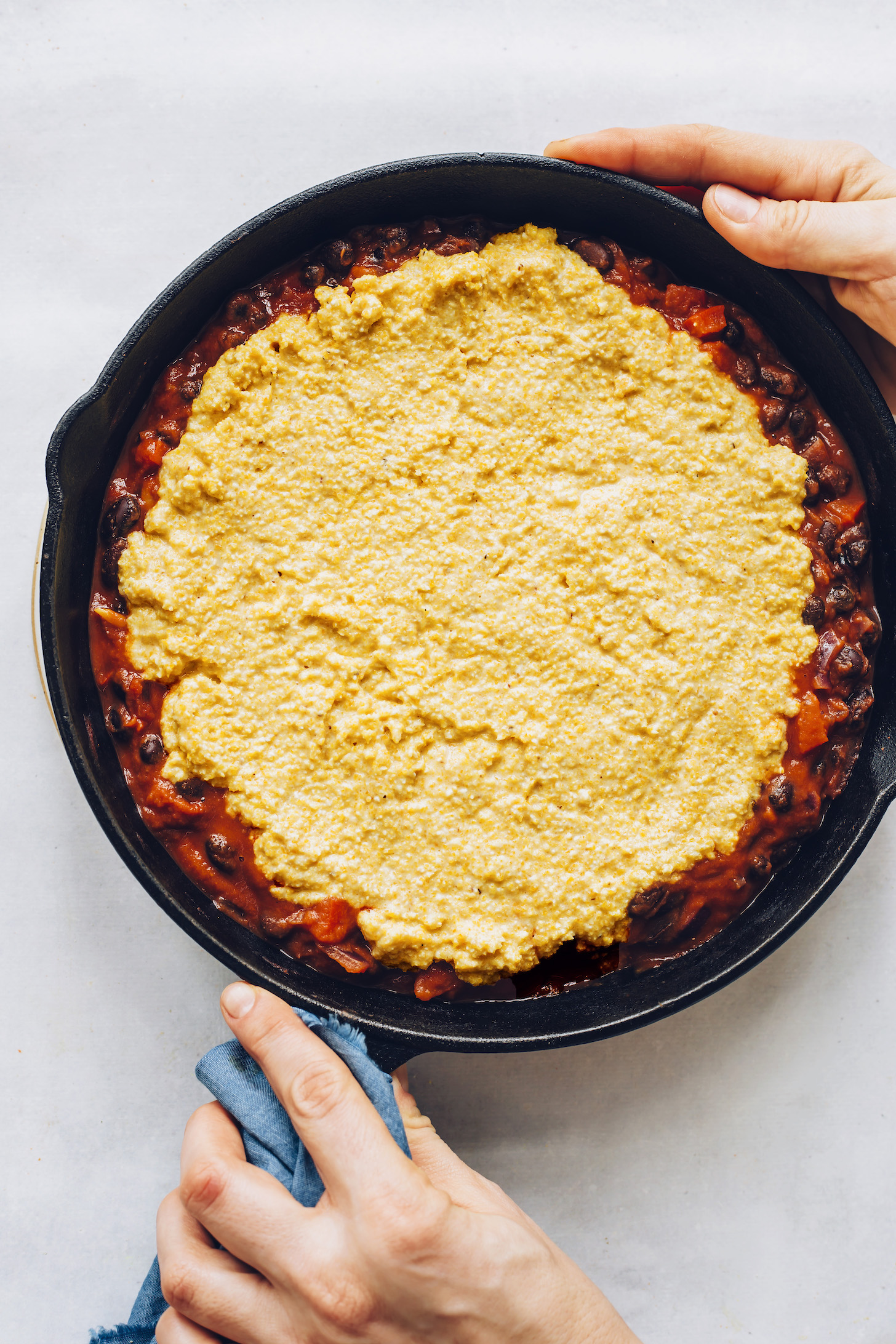 Cornbread topping spread over enchilada filling