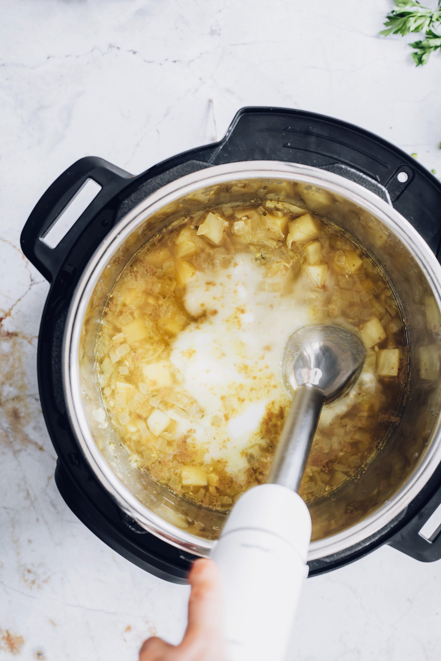 Using an immersion blender to blend green split pea soup in the Instant Pot