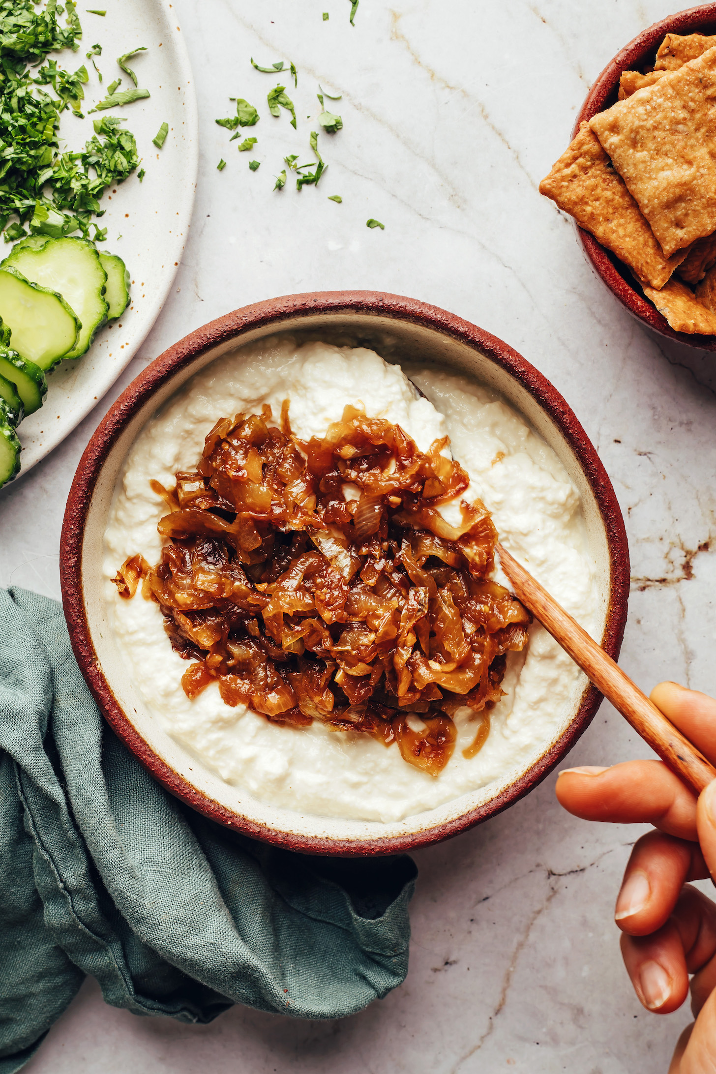 Stirring caramelized onions into a creamy silken tofu base