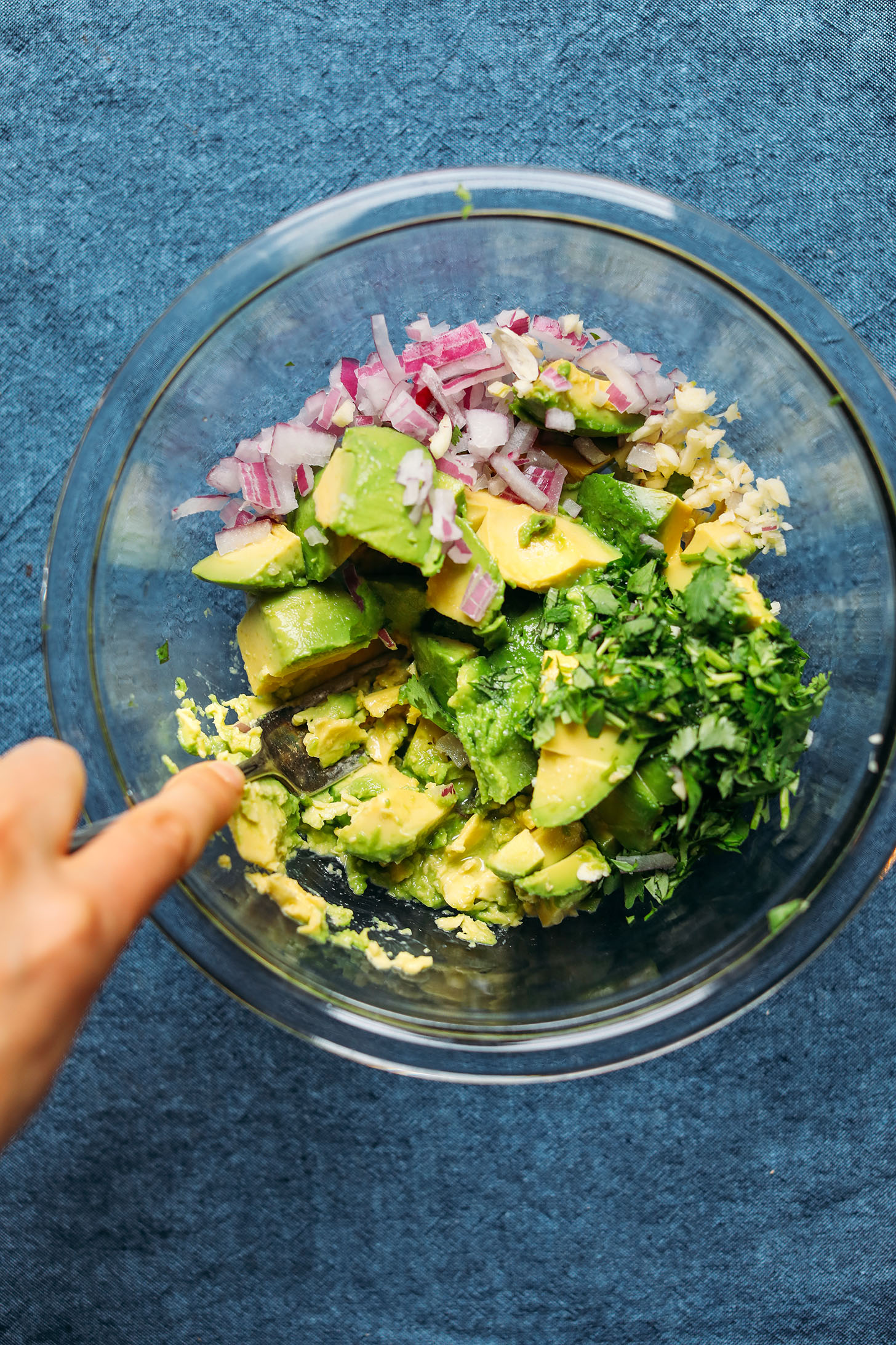 Using the back of a fork to mash avocado for Garlicky Guacamole