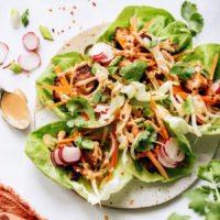 Platter of crispy tofu lettuce wraps with fresh vegetables and peanut sauce