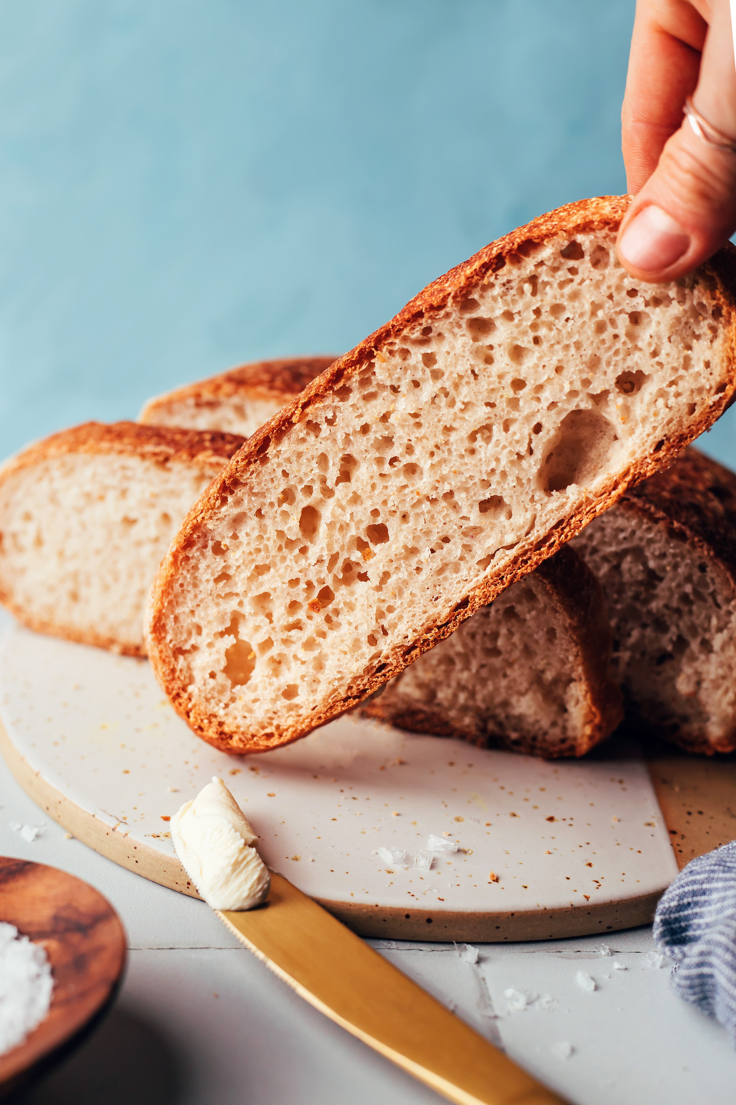 Holding a slice of gluten-free artisan bread next to more slices