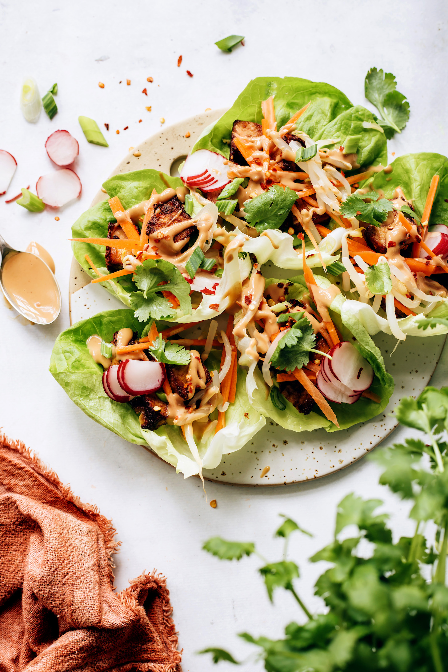 Tray filled with tofu lettuce wraps drizzled with peanut sauce