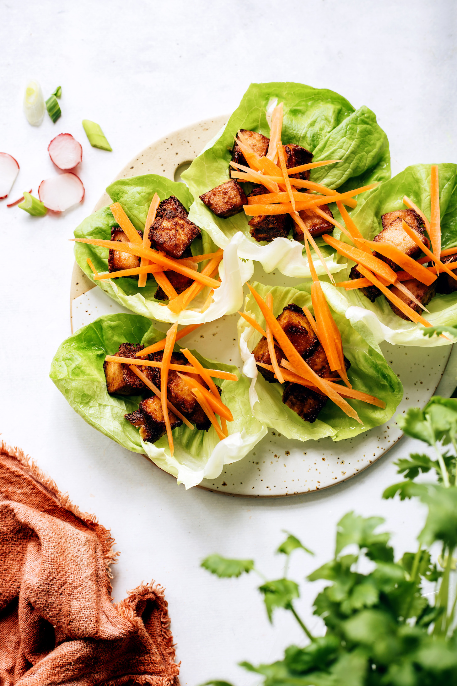 Lettuce leaves topped with crispy tofu and sliced carrots