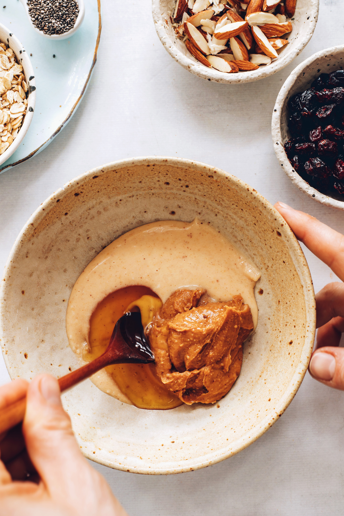 Mixing cashew butter, almond butter, and maple syrup in a bowl