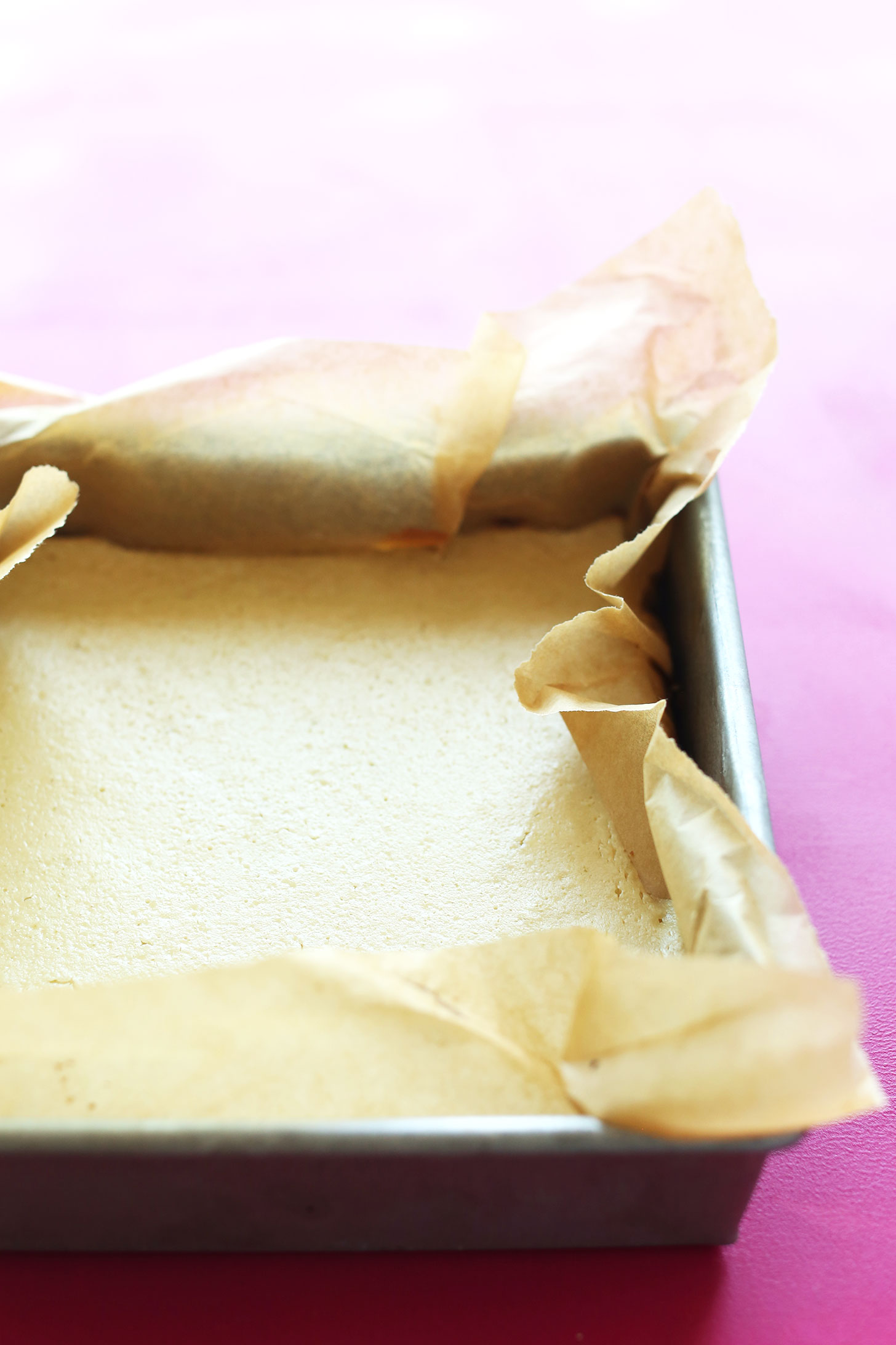 Parchment-lined baking pan filled with our gluten-free vegan Key Lime Pie Bars recipe