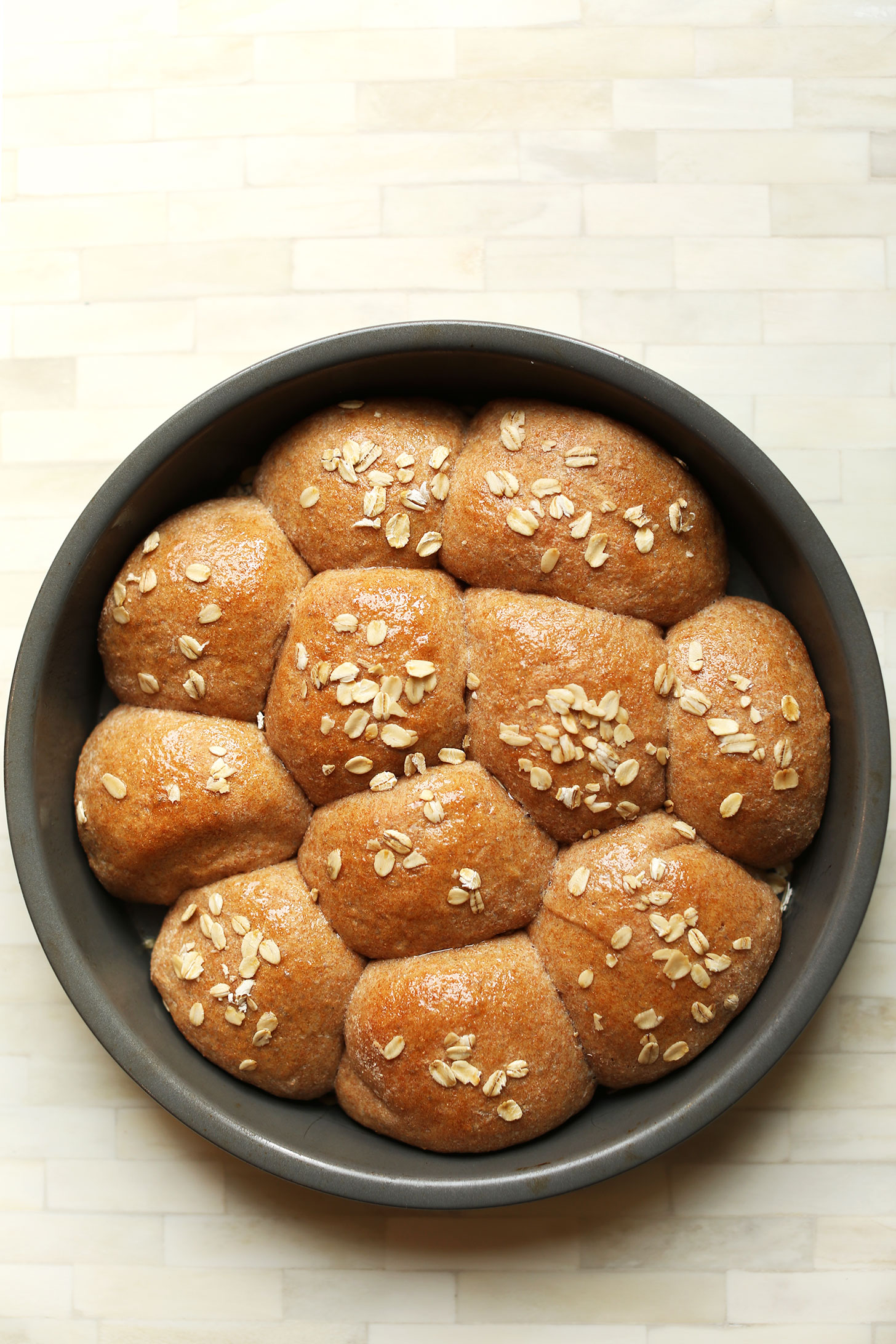 Freshly baked vegan Spelt Dinner Rolls in a round baking pan