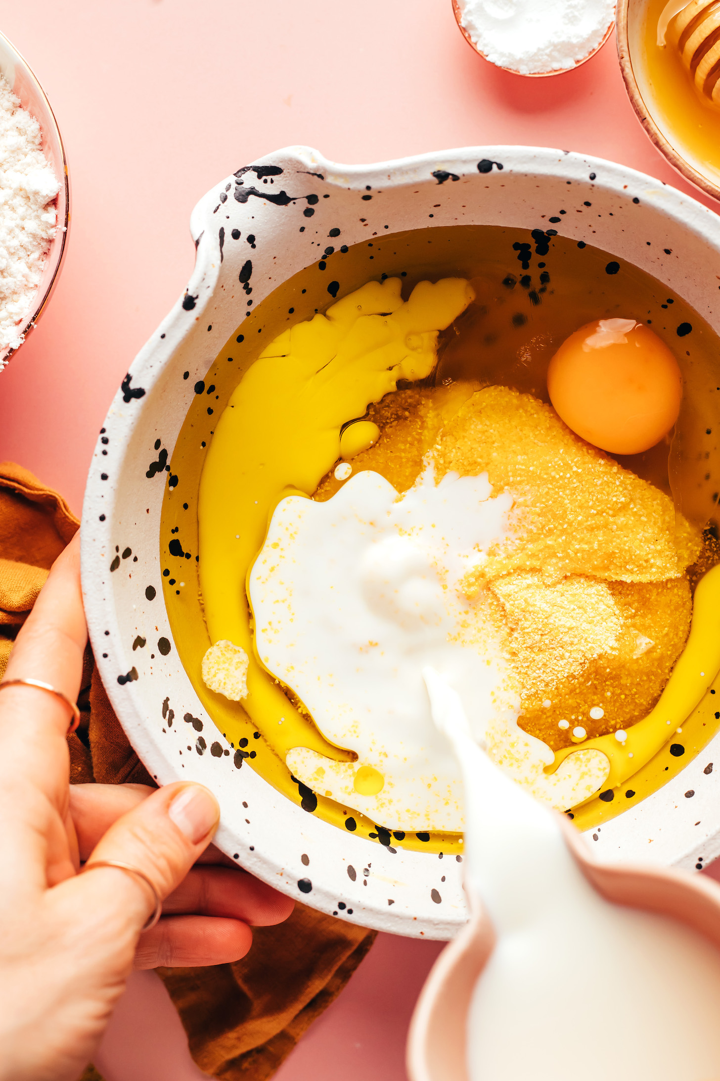 Pouring dairy-free milk into a bowl with other wet ingredients