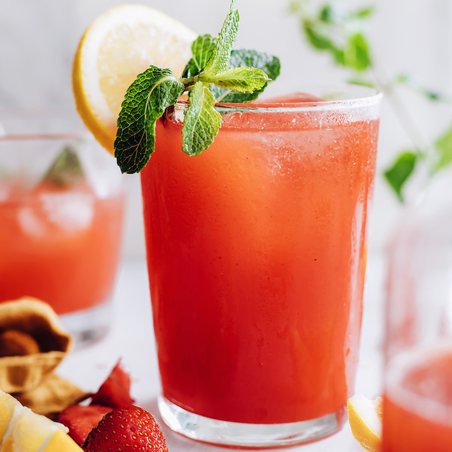 Glass of homemade strawberry lemon with a lemon slice on the rim