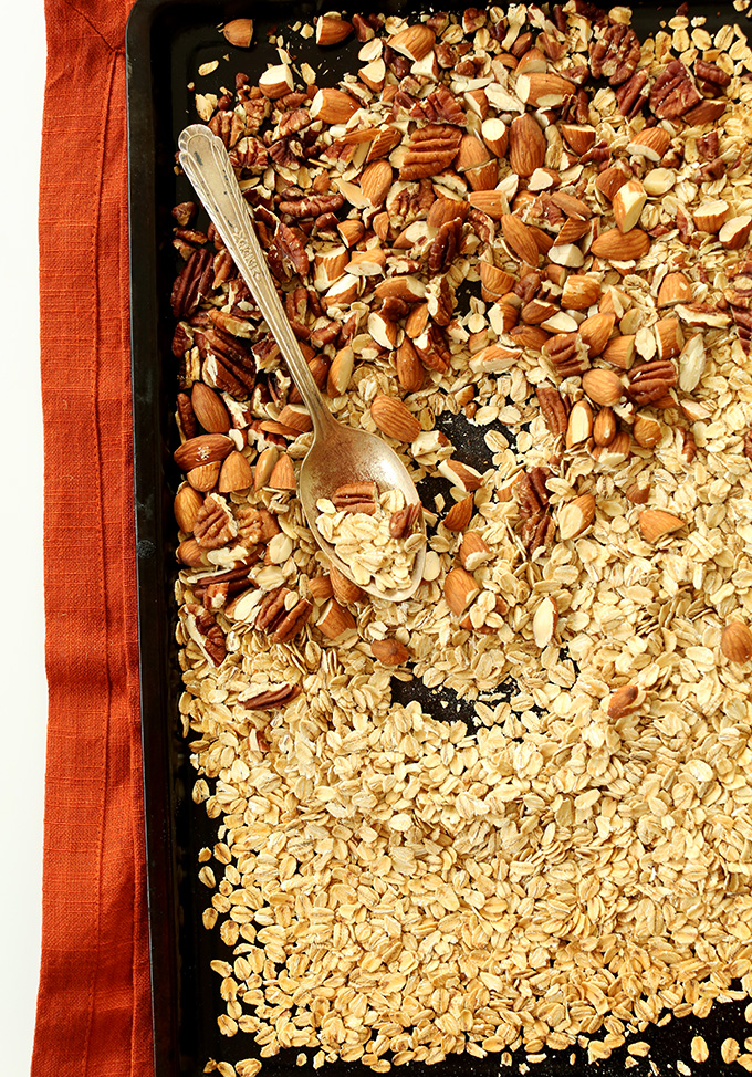 Baking sheet filled with oats, almonds, and pecans for making Healthy Brownie Granola Bars