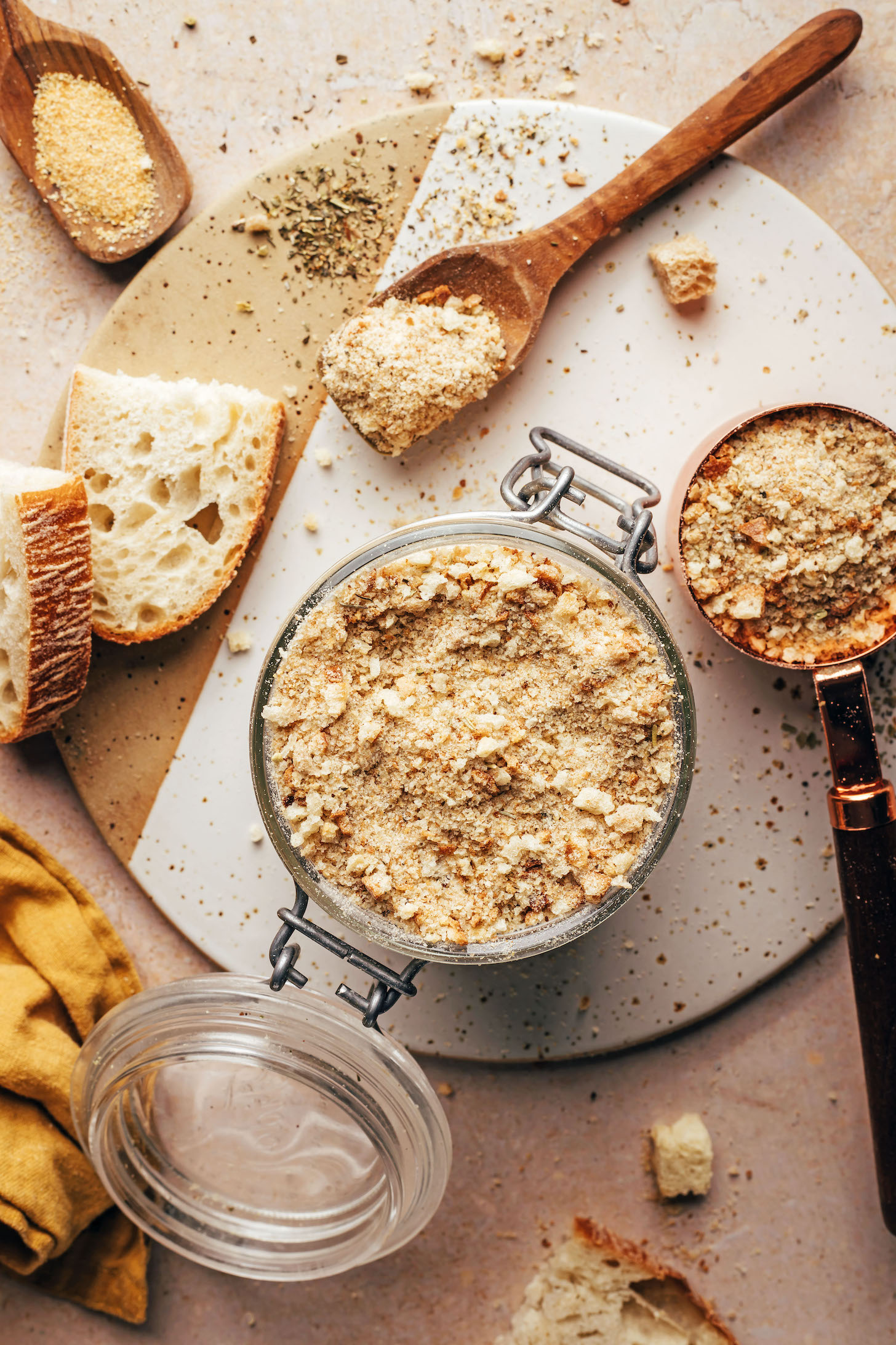 Jar and measuring cup of breadcrumbs next to ingredients used to make them