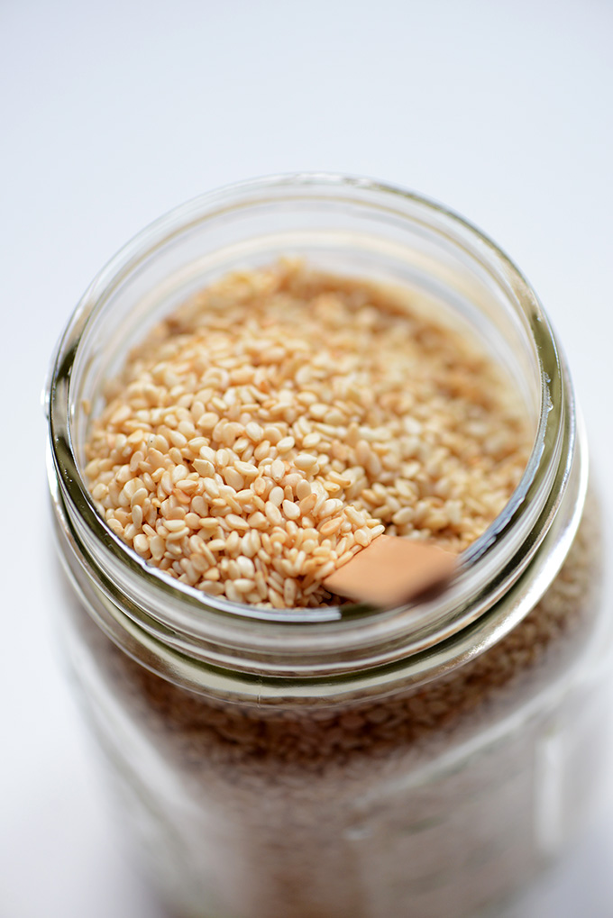 Spoon in a jar of sesame seeds for making our homemade tahini recipe