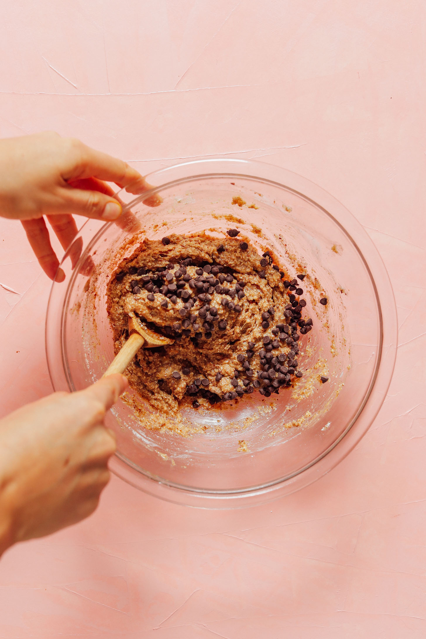 Using a wooden spoon to stir chocolate chips into Banana Cookie Dough batter