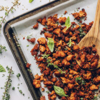 Wooden spoon resting on a pan of Italian herb baked tofu