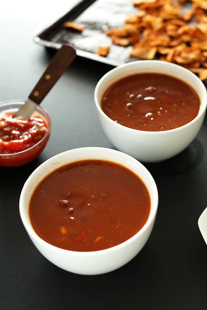 Bowls of Loaded Veggie Nacho Soup and a baking sheet of chips