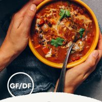 Holding a bowl of Pumpkin Black Bean Soup made with Thai and Mexican flavors