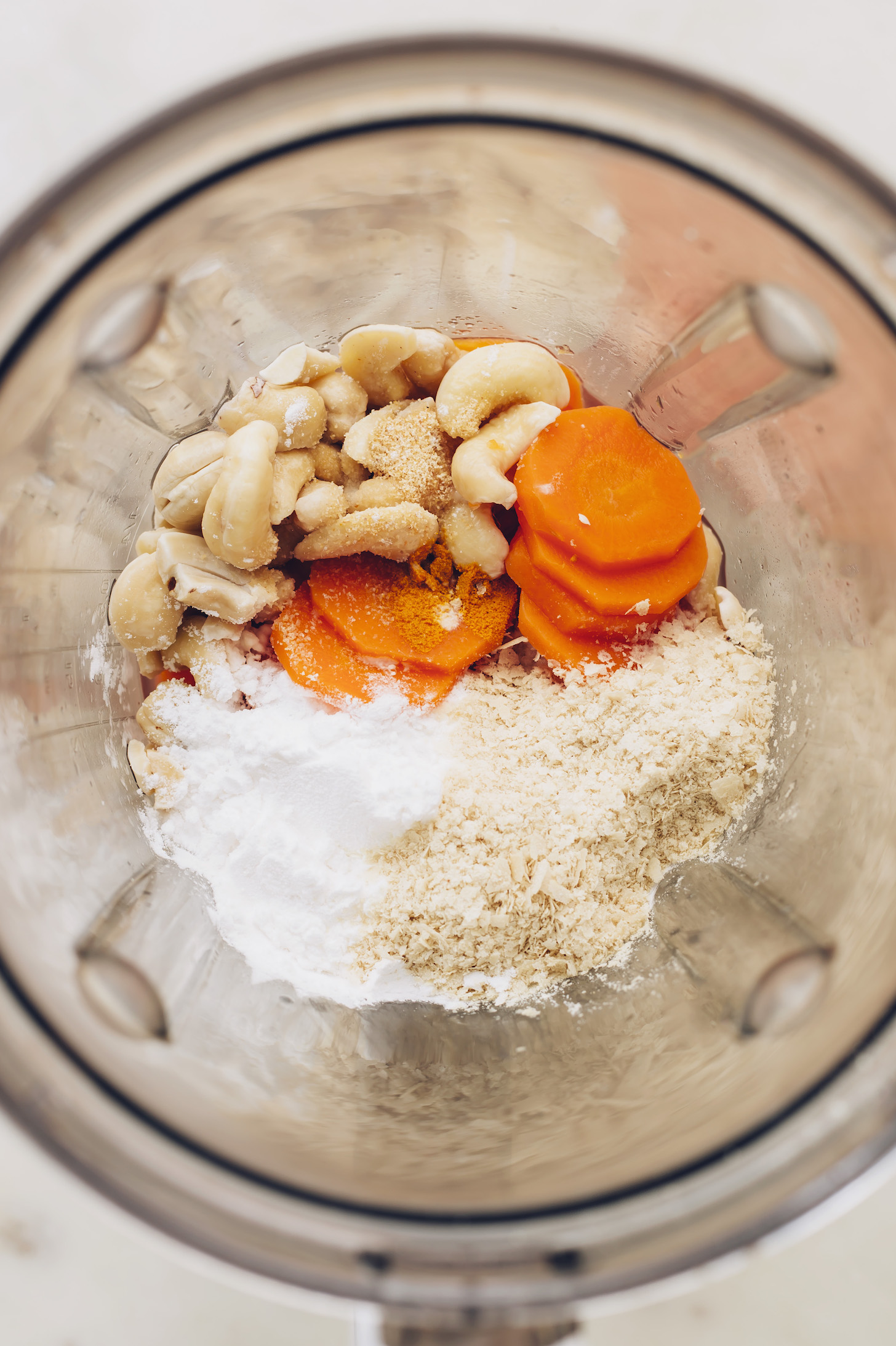 Blender with carrots, cashews, nutritional yeast, tapioca starch, apple cider vinegar, and spices