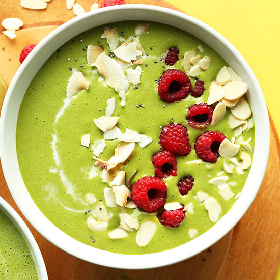 Matcha Green Smoothie Bowl topped with coconut flakes, slivered almonds, and fresh raspberries