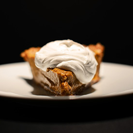 Plate with a slice of No Bake Pumpkin Pie topped with coconut whipped cream