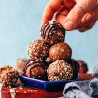 Picking up a nut-free tahini snack bites from a stack of more energy bites