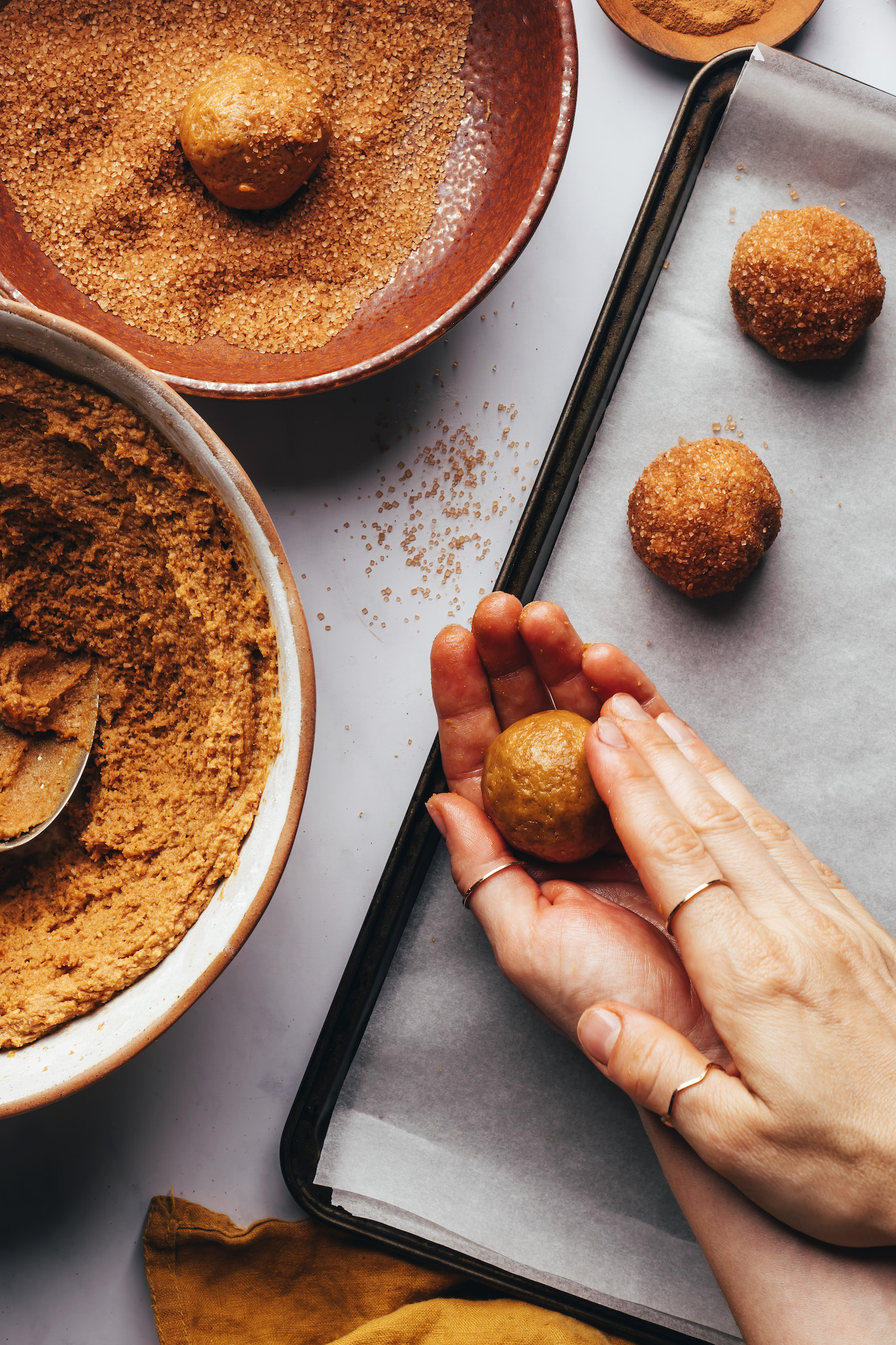 Rolling a ball of pumpkin snickerdoodle cookie dough in hands