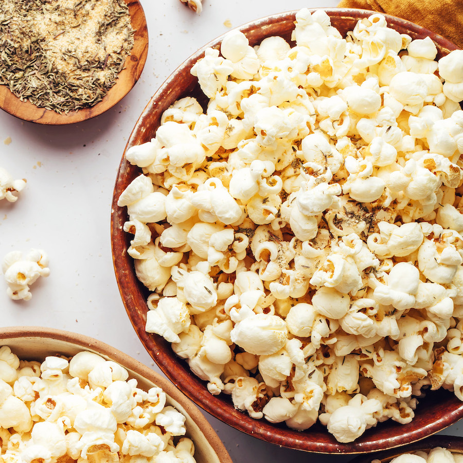 Overhead shot of bowls of homemade popcorn and seasonings