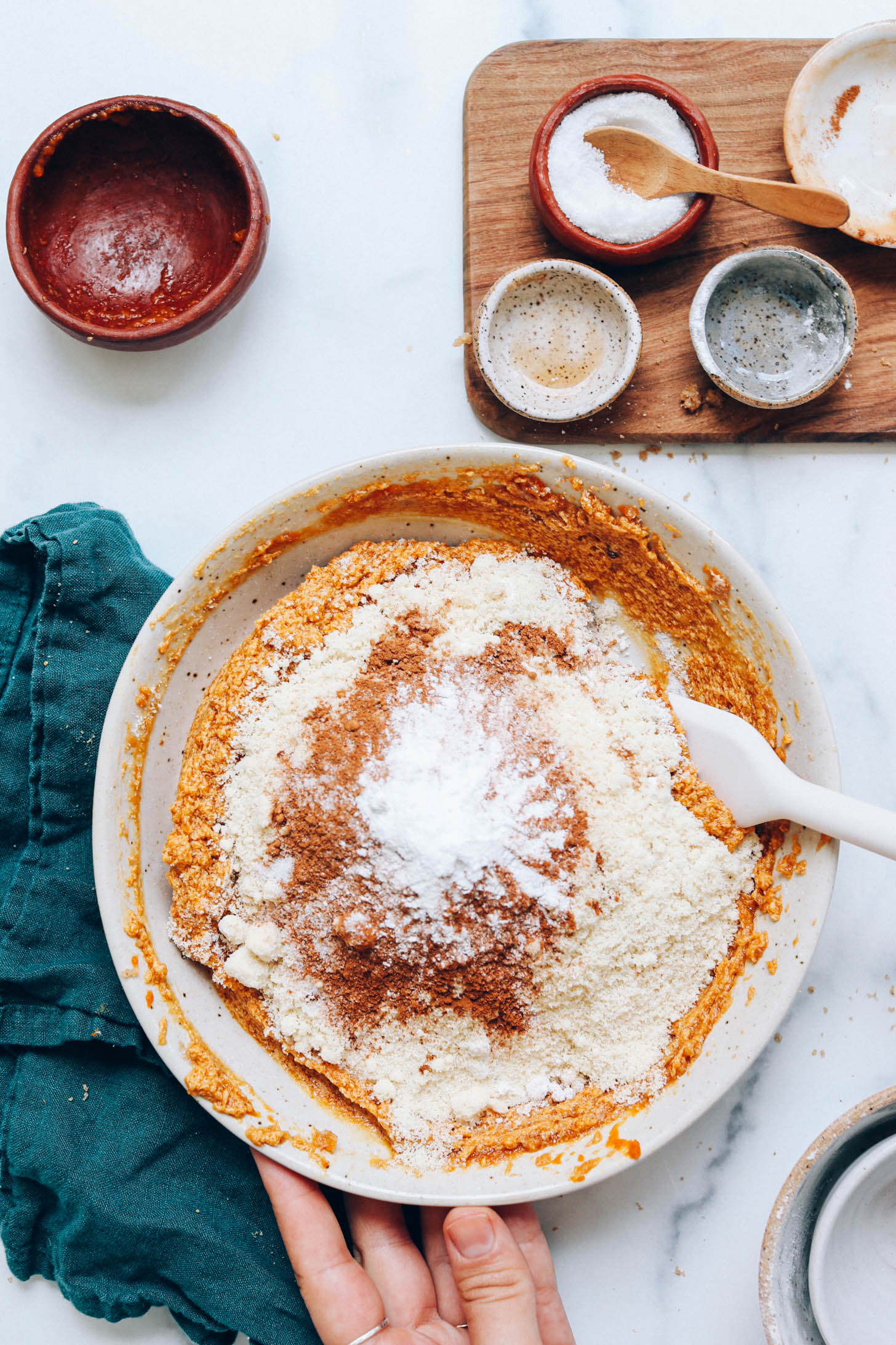 Gluten-free flour blend, almond flour, spices, and baking powder in a mixing bowl over the wet ingredients