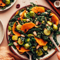 Using serving utensils to mix our Roasted Fall Vegetable Salad recipe