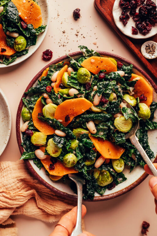 Using serving utensils to mix our Roasted Fall Vegetable Salad recipe