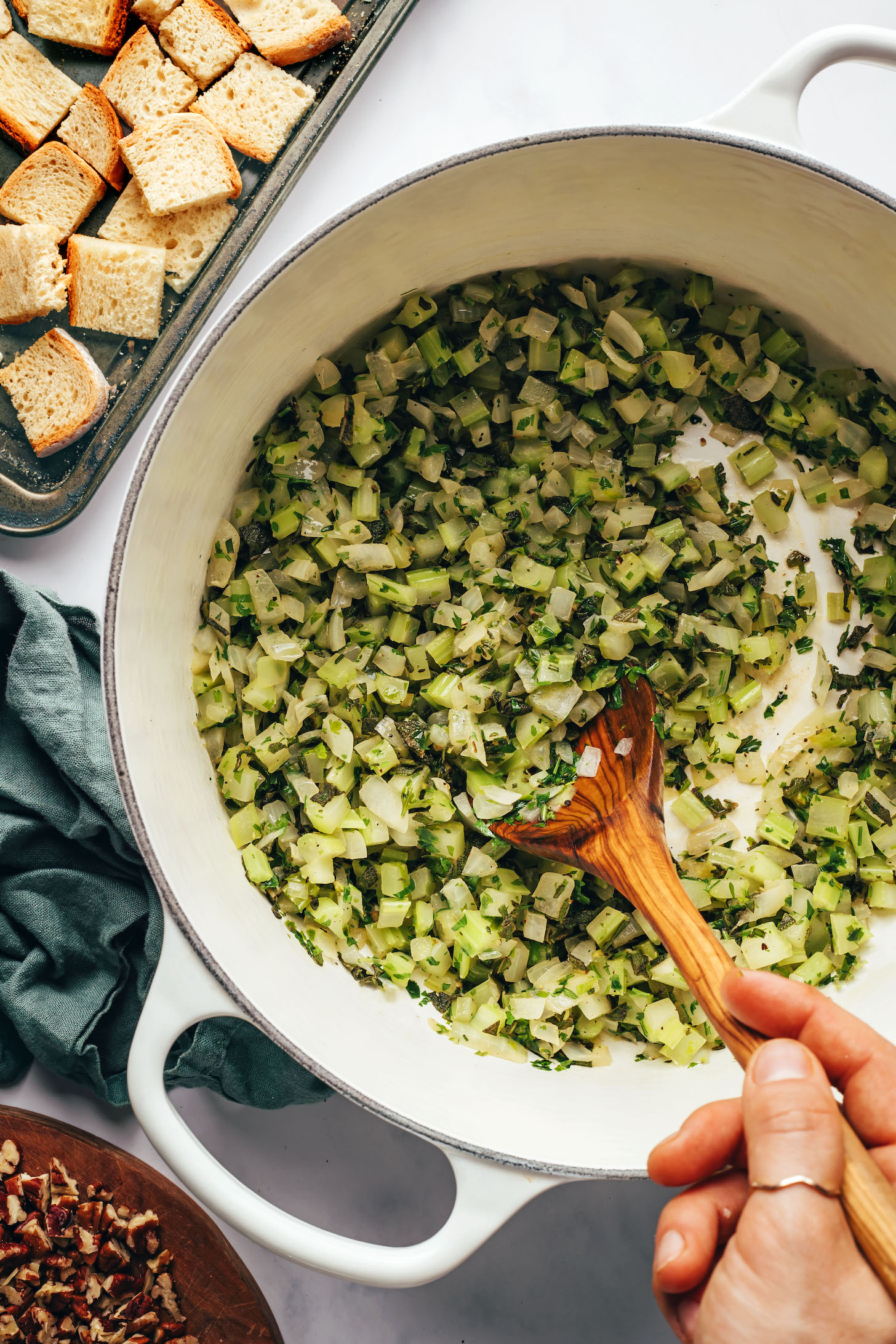 Sautéing onion, celery, and fresh herbs in a Dutch oven