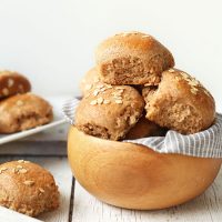 Bowl and tray of Fluffy Vegan Spelt Rolls topped with oats