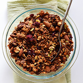 Spoon in a glass bowl filled with Sweet Potato Granola