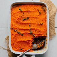 Pan of Vegan Sweet Potato Shepherd's Pie with a spoonful removed