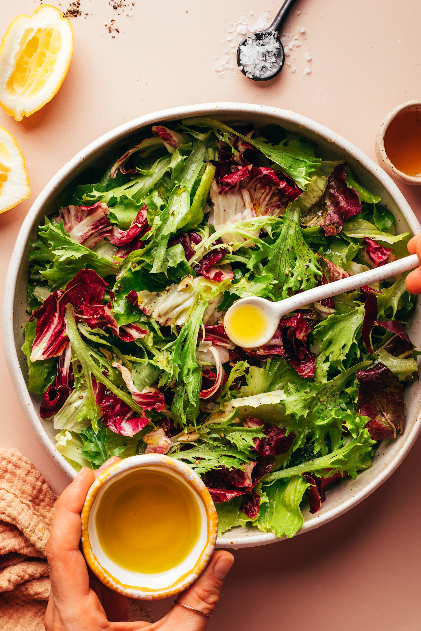 Drizzling a simple lemon vinaigrette over a big bowl of greens