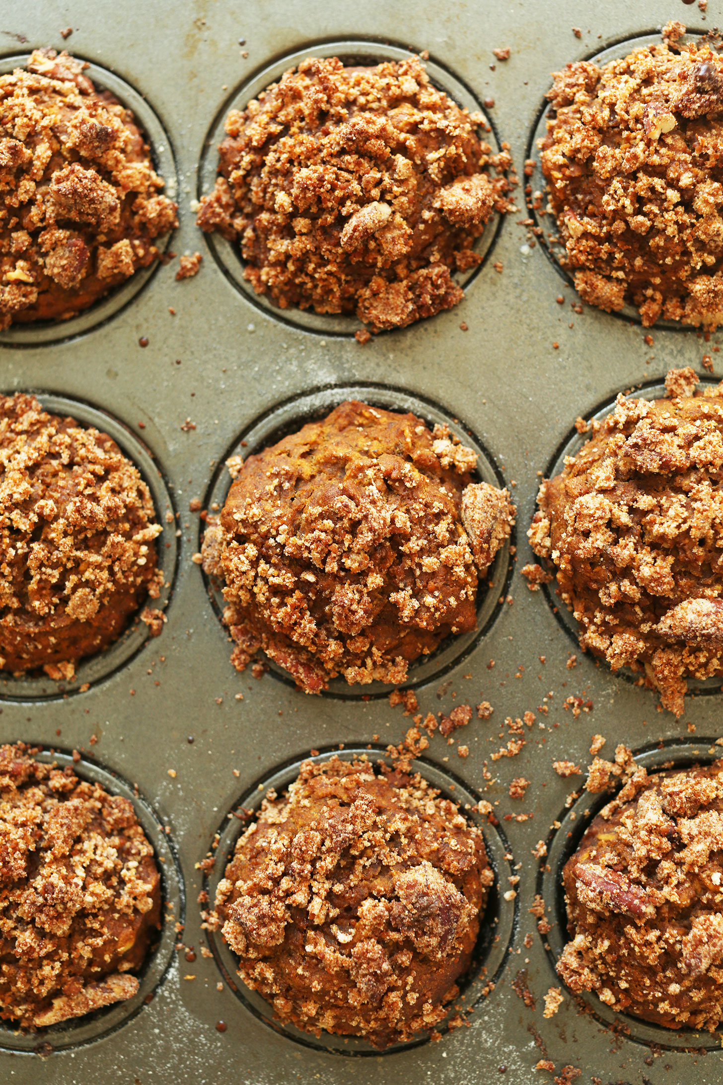 Muffin tin filled with freshly baked Vegan Pumpkin Spice Muffins with a Pecan Crumble Topping